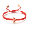 Close-up of red woven evil eye bracelet with triangular gold-rimmed pendant detail - Red