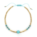 Detailopname van geweven boho-armband met turquoise kralen en gouden kubussen op wit - Goud-Lichtblauw (XN227-g-lightblue)