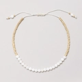 Detalle de una pulsera bohemia con cuentas blancas y cuentas de metal dorado - Blanco (XN278-white1)