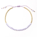 Detalle de pulsera de cuentas moradas claras con espaciadores dorados y cordón ajustable - Estilo Violeta Claro (XN278-purple1)