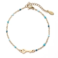 Details eines goldenen Edelstahlarmbands mit blauen Perlen und Herz-Schlüssel-Anhänger - Ozeanblau