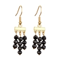 Retro beach style gold dangle earrings with faceted black beads in a tiered design - Black
