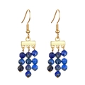 Detail of gold drop earrings featuring layered blue faceted stones for beach vacation - Blue