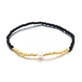 Pulsera elástica bohemia con cuentas negras, detalles dorados y perla blanca - Negro