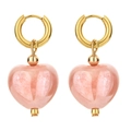 Pink heart pendant earrings with gold hoops and stone texture on white background - Pink