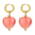 Detailed macro view of golden hoop earrings featuring peach heart-shaped ceramic pendants - Coral Pink