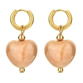 Close-up of heart shaped ceramic pendant earrings with gold hoops and polished finish - Flesh Pink