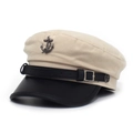 Close-up of vintage metal anchor emblem and black leather strap on nautical cap - Beige