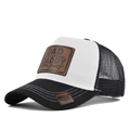 Detail of truck hat showing brown leather patch and white stitching on black brim - Black & White