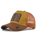 Detail of the yellow trucker hat featuring a leather patch and American flag embroidery - Light Coffee & Caramel