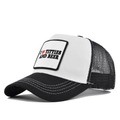 Detail des bestickten Aufnähers auf einer schwarz-weißen Trucker-Cap mit Netzeinsatz - Schwarz & Weiß