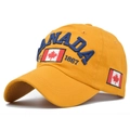 Dettaglio del cappellino in cotone giallo con ricamo CANADA blu e stemma foglia d'acero - Regolabile / Giallo