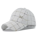 Detailed texture of white tweed baseball cap with gold metallic thread and M logo - Metallic Letter M Decor Style / White