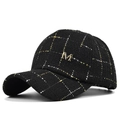 Close-up of black tweed baseball cap with gold grid pattern and metal M logo detail - Metallic Letter M Decor Style / Black