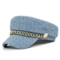 Detail of blue tweed newsboy cap with gold chain and embossed heraldic button decoration - M / Blue