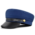 Detalle de gorra marinera azul marino con visera de cuero negro y botón dorado lateral - M / Azul