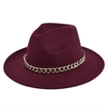Detail van bordeauxrode wollen fedora hoed met een grove gouden metalen ketting - Bordeauxrood