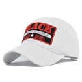 Detailaufnahme einer weißen Baseballkappe mit rundem BLACK REBEL Stickaufnäher aus Baumwolle - Weiß