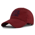 Macro detail of wine red baseball cap featuring vintage distressed brim and letter embroidery - Red