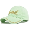 Close-up of golden 3D embroidery and vintage lettering on washed cotton baseball cap - Fluorescent Green