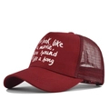 Detail of maroon trucker hat showing breathable mesh back and white screen printed text - Adjustable / Burgundy