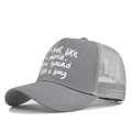 Detail of grey trucker hat featuring white text print and breathable mesh back - Adjustable / Gray