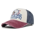 Detail of vintage eagle embroidery and Omaha Beach Normandy text on distressed baseball cap - Burgundy