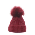 Close-up of wine red ribbed knit beanie featuring a large fluffy faux fur pompom on top - M (56-58cm) / Burgundy