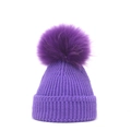 Close-up of deep purple knit beanie featuring a large fluffy pom-pom and ribbed texture - M / Purple