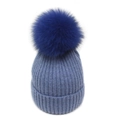 Close-up of winter knit beanie with ribbed texture and oversized faux fur pompom decoration - M / Light Blue