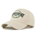 Close-up of the detailed green embroidery text on a cream cotton twill baseball cap - Beige