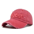 Close-up of vintage red washed cotton baseball cap featuring 3D NEW YORK embroidery and distressed details - Red