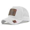 Close-up of white trucker hat featuring breathable mesh and embossed brown leather patch - White