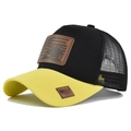 Close-up of contrast trucker hat featuring breathable mesh and leather tractor patch - Yellow Black Patchwork