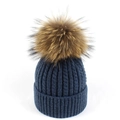 Dettaglio del berretto in maglia a trecce blu scuro con un morbido pompon in pelliccia marrone - Blu navy
