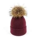 Detalle del gorro de punto granate con un pompón de piel de mapache suave y esponjoso - Burdeos
