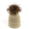 Dettaglio del berretto in maglia a coste beige con un grande pompon in pelliccia morbida - Adulto / Beige