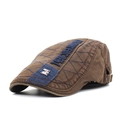 Detail of a brown quilted beret hat featuring blue stitching and a metallic M logo - Adjustable / Coffee
