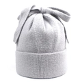 Detailed close-up of light gray knitted beanie with large bow accent and ribbed edge - M (56-58cm) / Gray