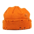 Macro detail of orange knit beanie with metal safety pin and rings on distressed brim - Orange