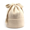 Detailed close-up of a cream-colored ribbed knit beanie featuring a large decorative bow knot - M (56-58cm) / Beige