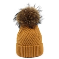 Berretto in maglia giallo senape con grande pompon in pelliccia marrone su sfondo bianco - Giallo