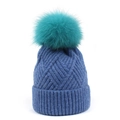 Detail of navy knit beanie texture with a fluffy teal faux fur pom pom on top - One Size / Blue