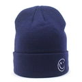 Dettaglio ravvicinato del berretto in maglia blu navy con logo smile bianco ricamato sul risvolto - Faccina Sorridente Blu Notte