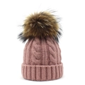 Detail of pink cable knit beanie featuring a large faux fur pompom and soft texture - Pink