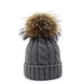 Detailed view of dark grey cable knit beanie with large faux fur pompom for winter - Gray