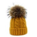 Detail of cable knit pattern and faux fur pompom on ginger yellow winter beanie - Adult / Yellow