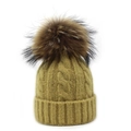 Close-up of mustard yellow cable knit hat with a large fluffy brown faux fur pompom detail - Khaki