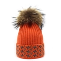 Close-up of orange knitted winter hat with brown pompom and star pattern cuff - M (56-58cm) / Orange