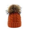 Close-up of orange cable knit beanie with fluffy pom-pom and thick ribbed cuff detail - Orange